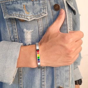 Close-up of silver titanium steel C-shaped cuff bracelet with rainbow pride enamel detail