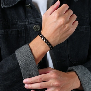 Nahaufnahme eines schwarzen Edelstahl-Panzerarmbands am Handgelenk eines Mannes