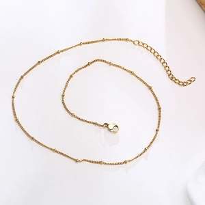Detailed view of gold stainless steel beaded chain necklace with lobster clasp and extender