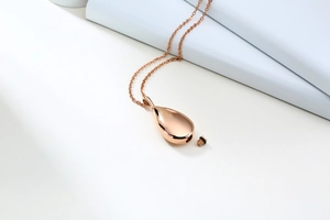 Close-up of rose gold teardrop urn pendant with secure screw seal and polished finish