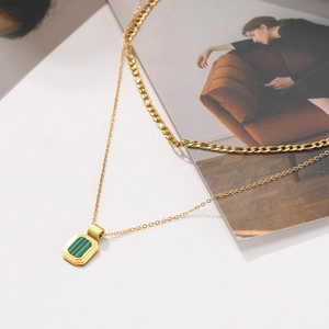 Detail of layered gold stainless steel necklace with green malachite geometric pendant