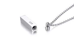 Detailed macro view of silver rectangle urn pendant with three zircons and screw opening