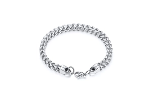 Détail macro de la texture de maille épi argentée et du fermoir sur bracelet en acier
