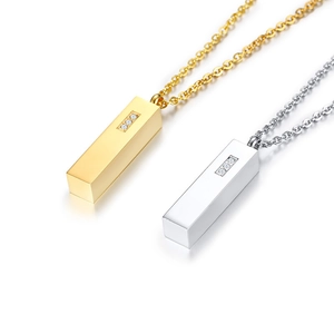 Macro detail of vertical bar cremation pendants in gold and silver with three zircon stones