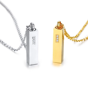 Close-up of gold and silver steel column cremation urn pendants with inset crystals