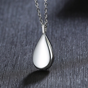 Close-up of polished silver teardrop urn pendant on a delicate link chain necklace