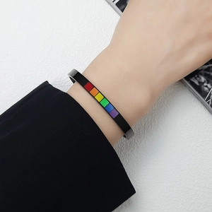 Polished black titanium steel C-shaped cuff bracelet with rainbow enamel inlay on wrist
