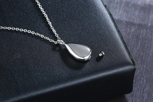 Macro view of teardrop cremation urn necklace showing the screw cap and polished surface