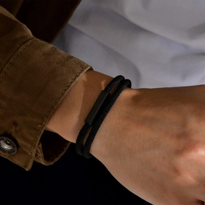 Detail view of men's double-layer black woven cord bracelet with matte magnetic clasp