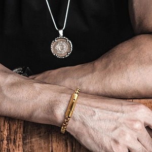 Close-up of men's chunky gold stainless steel box chain bracelet with cylinder clasp