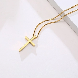 Detailed view of a gold stainless steel cross pendant featuring a polished box chain link
