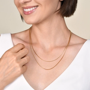 Minimalistische zweilagige goldene Edelstahlkette an Modelhals mit V-Ausschnitt-Top