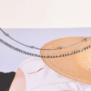 Detail of silver double-layer set featuring Figaro chain and beaded snake chain