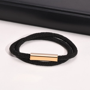 Detail of double-layer black Milan rope bracelet with polished gold magnetic clasp