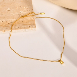 Minimalist gold stainless steel necklace with square padlock pendant on stone surface