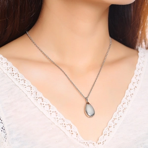 Polished silver teardrop cremation urn necklace for women on a model neck with lace