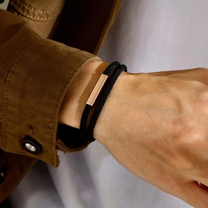 Close-up of double-layer black Milan rope bracelet with rose gold magnetic bar