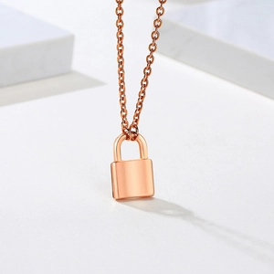 Detail view of a rose gold lock pendant necklace on a premium white marble background