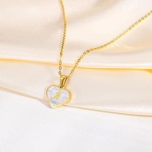 Golden heart necklace with pearl shell inlay and letter A pendant on silk