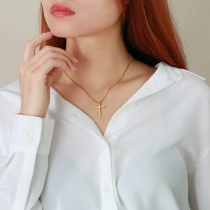 Minimalist gold stainless steel cross pendant necklace with a fine link chain on model