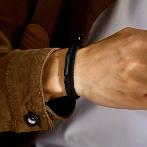 Double-layered black braided rope bracelet with magnetic metal buckle on model wrist