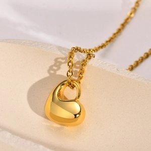 Detailansicht des herzförmigen Urnenanhängers in poliertem Gold mit minimalistischer Kette