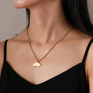 Elegante collana con ciondolo a cuore puzzle in acciaio dorato indossata da una modella