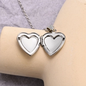 Silver stainless steel heart locket necklace with open dog paw design and photo slots