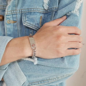Gros plan d'un bracelet d'alerte médicale avec l'étoile de la vie sur acier inoxydable