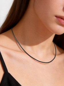 Close-up of black braided wax rope choker necklace showing texture on a model