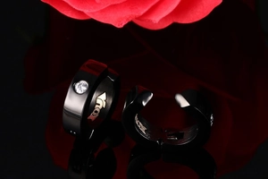 Détail d'une boucle d'oreille noire en acier inoxydable avec zircon et gravure NOX interne