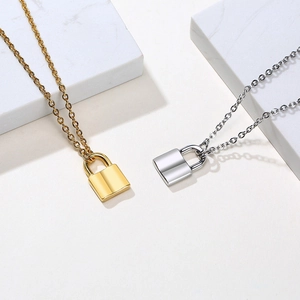 Minimalist stainless steel padlock pendant necklaces in gold and silver on marble blocks