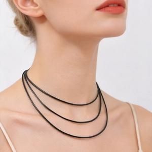 Close-up of three-layered black wax cord necklace worn by a female model