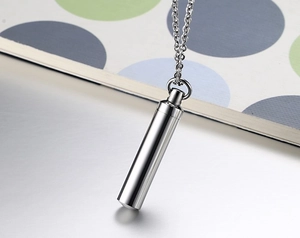 Macro detail of high-polish stainless steel cylindrical perfume bottle pendant necklace
