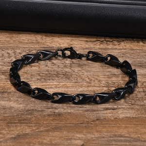 Macro view of polished black stainless steel chain links with secure lobster clasp