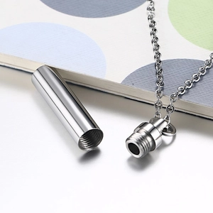 Macro detail of cylindrical stainless steel perfume pendant with threaded screw cap design