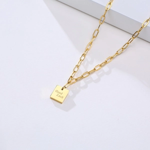 Macro du pendentif carré doré en acier inoxydable avec gravure Good Luck et chaîne trombone