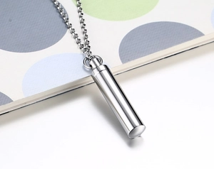 Macro shot of polished stainless steel cylinder pendant with a high-shine mirror finish
