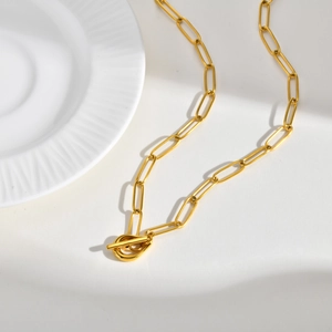 Close-up of golden stainless steel paperclip chain necklace with a classic OT buckle