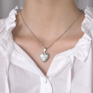 Dettaglio della collana con medaglione a cuore in argento e incisione a zampa