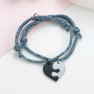 Detail of blue braided couple bracelets with magnetic heart puzzle pendants
