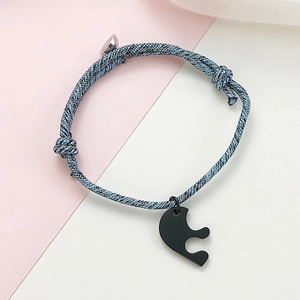 Braided heart puzzle couple bracelets with magnetic clasp on a soft pink and white backdrop