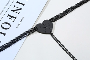 Detailed view of four black puzzle heart necklaces for friendship on an aesthetic background