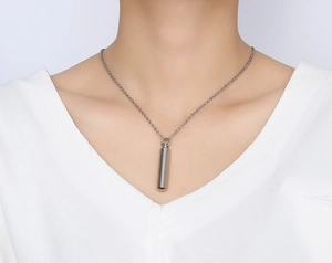 Minimalist silver cylindrical perfume bottle pendant necklace on model with O-chain