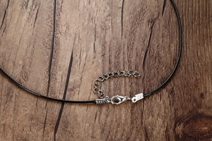 Macro shot of black wax rope necklace with silver lobster clasp and extension chain