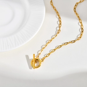 Detail of gold stainless steel paperclip chain necklace with a classic toggle OT clasp