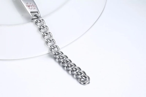 Vue macro d'un bracelet d'alerte médicale en acier poli avec symbole d'urgence
