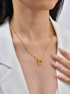 Golden OT clasp paperclip chain necklace styled on a white blazer for fashion visual