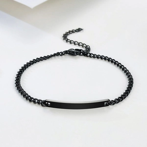Détail d'un bracelet noir en acier inoxydable avec barre gravable et chaîne à maillons