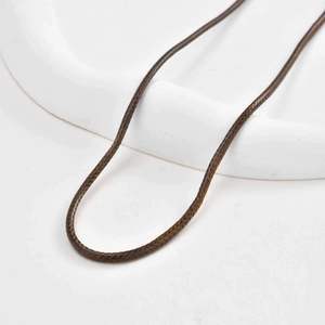 Dark brown braided wax rope necklace cord with spiral texture on white ceramic tray